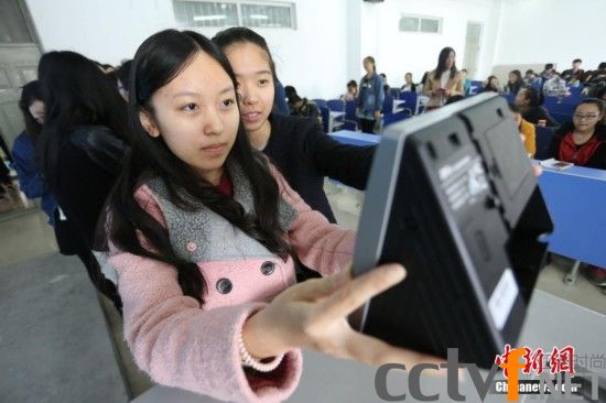 4月10日，河南工业大学新闻与传播学院播音专业的大学生们上课前用“人脸识别器”签到。杨正华 摄