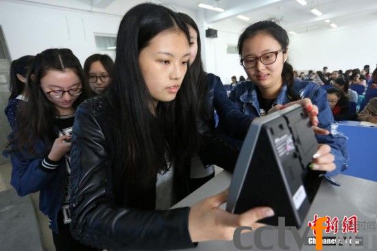 4月10日，河南工业大学新闻与传播学院播音专业的大学生们上课前用“人脸识别器”签到。 杨正华 摄